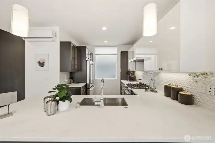 Gourmet kitchen with powerful range hood over five burner cooktop, and ultra-quiet Bosch dishwasher.