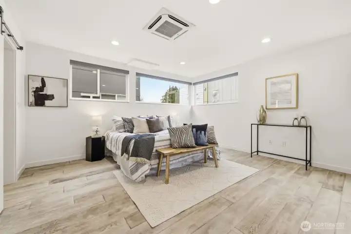 Oversized and air conditioned primary suite with sitting area, spacious custom closet, and heated tile floors in the primary bath.