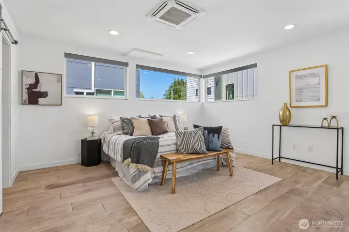 Oversized and air conditioned primary suite with sitting area, spacious custom closet, and heated tile floors in the primary bath.