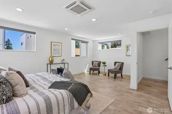 Oversized and air conditioned primary suite with sitting area, spacious custom closet, and heated tile floors in the primary bath.