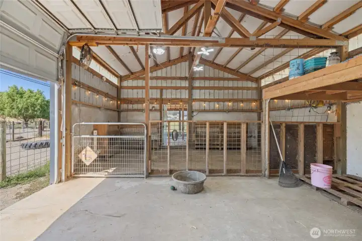 Barn- A car-charger plug is in place for added convenience. The space also features built-in livestock feeders, dedicated hay storage, and a defined pen area with durable concrete flooring. Cross-fencing completes the setup.