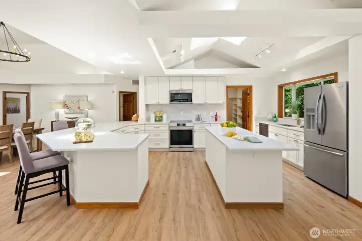 The remodeled chef's kitchen is complete with high end stainless appliances, quartz counters, custom cabinetry and a huge walk-thru pantry.