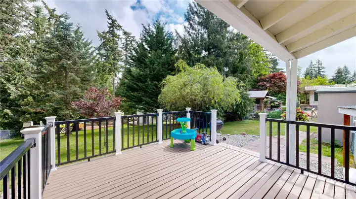 Large back deck steps right off the kitchen area, offering the perfect setup for summer BBQs and outdoor dining.