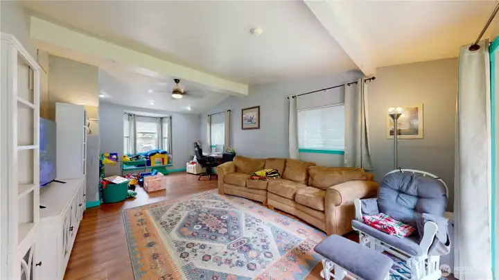 Family room features beautiful hardwood flooring and large windows that flood the space with natural light.