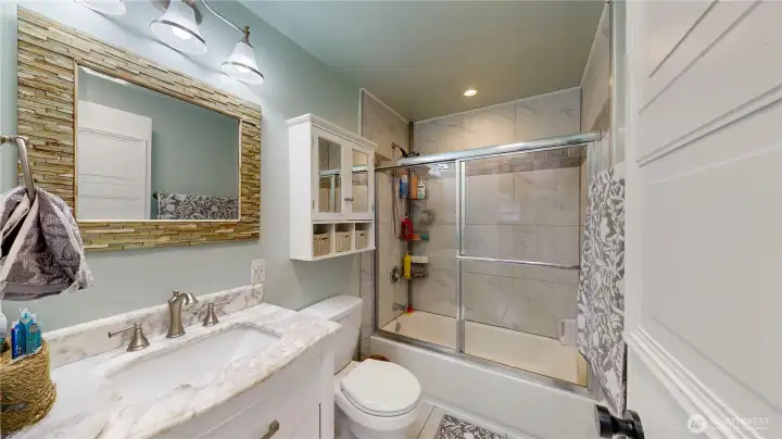 Bathroom featuring updated vinyl plank flooring and a tub/shower combo.