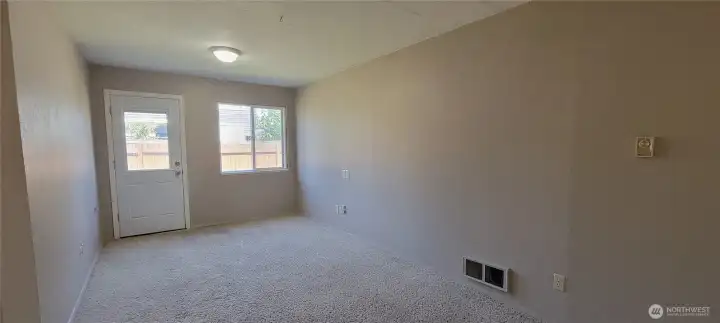 Bonus room off the kitchen, door leads out into the backyard.