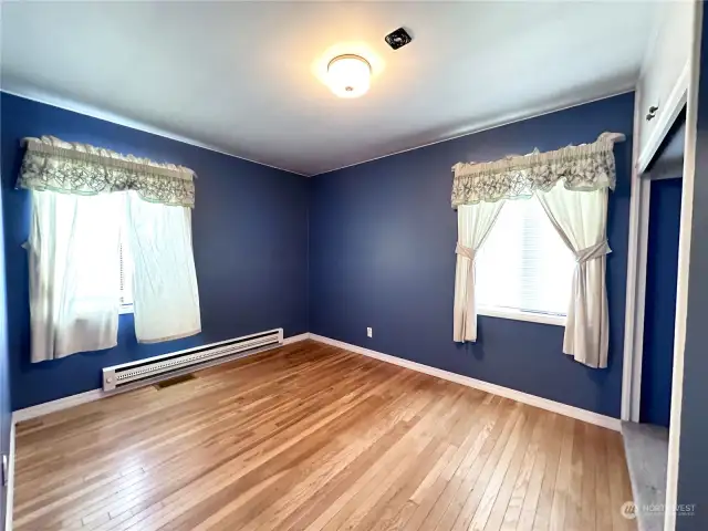 Guest bedroom 2 of 2 with exposed hardwood flooring