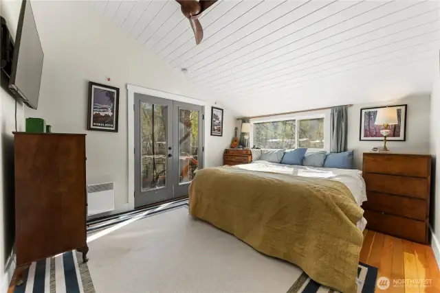 Main floor primary bedroom with French doors to small deck outside.