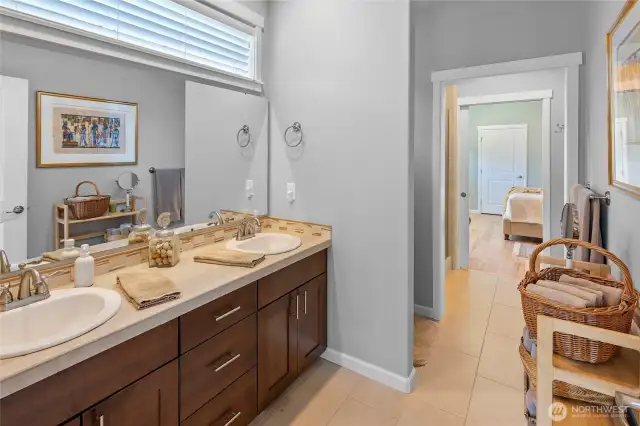 Primary suite with two-sink vanity, tiled shower and radiant heated floor.