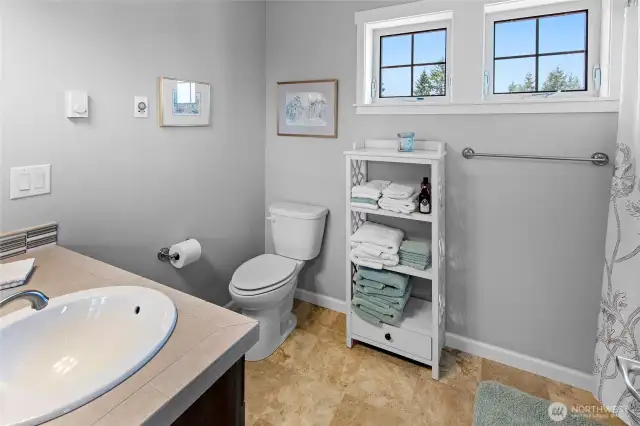 Upper level guest bathroom with sink, toilet, tub and shower.