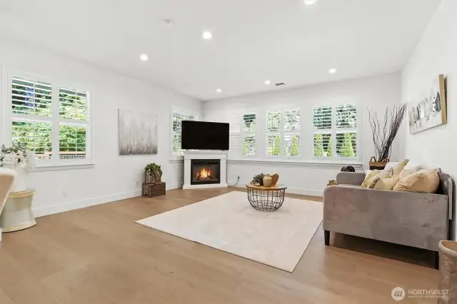 The informal living area off the kitchen nook and kitchen offers so much space, light, and even an electric fireplace for enjoyment.