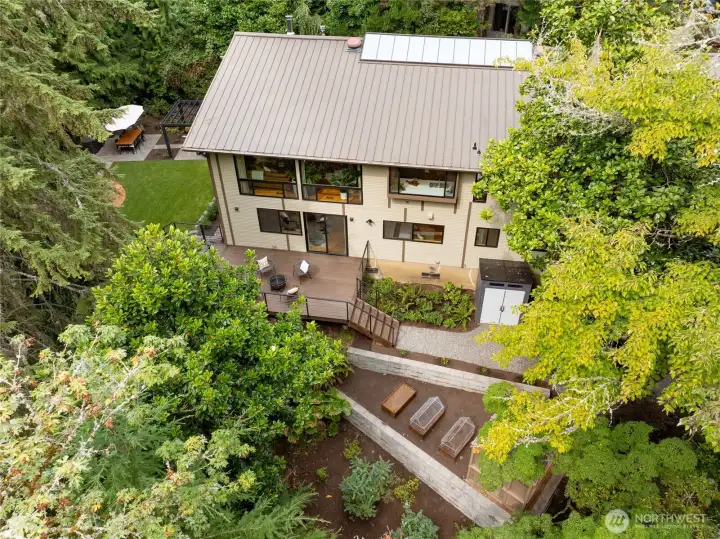 Aerial view of the deck, greenhouse and garden areas. The long-life metal roof on the home gives you peace of mind as well!
