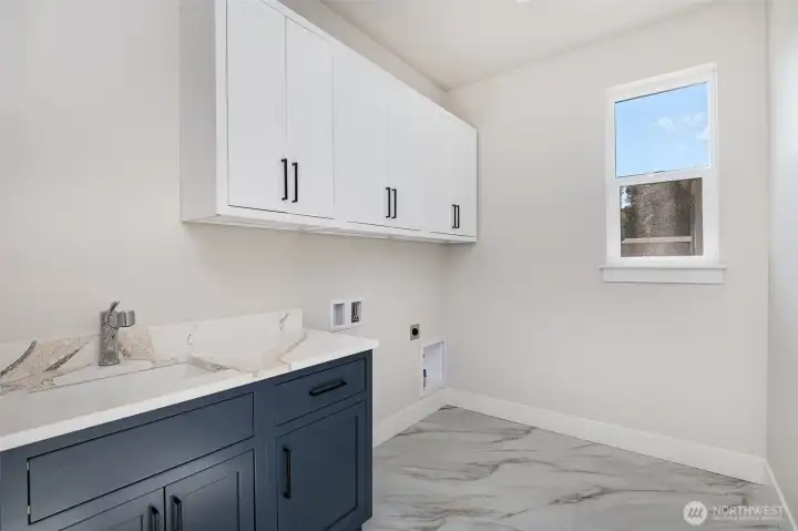 Generous laundry room on upper level, includes sink and plenty of storage