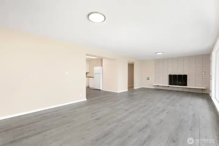 Large living room with cozy fireplace and updated flooring creates a clean, modern feel.