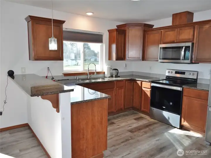 Kitchen w/ Stainless Steel Appliances and slab granite counters.
