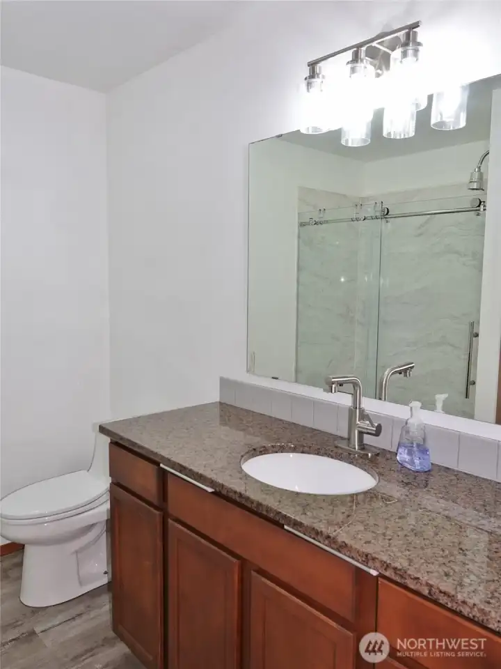 Bathroom w/ slab granite counters.