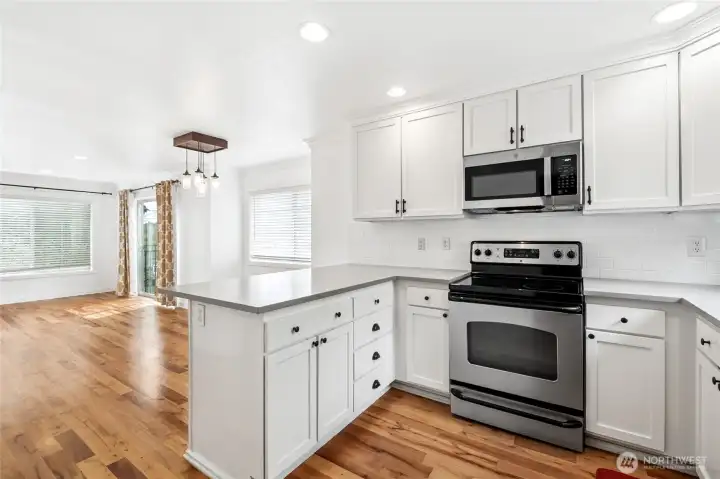 Clean, bright, remodeled kitchen with solid wood cabinetry, subway tile, quartz countertops, and lots of storage space.