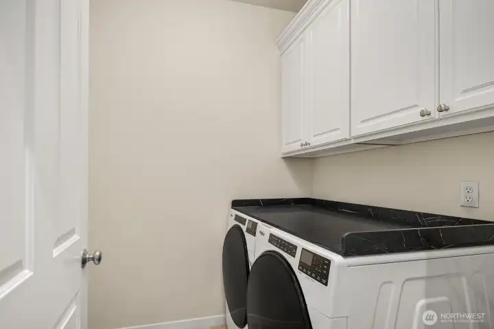 Utility room with built in cupboards on both walls and a large alcove to the left