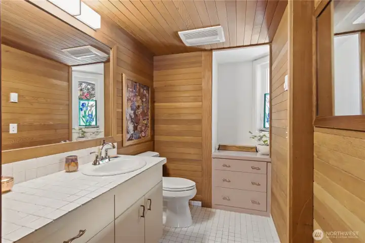Charming wood lined powder room on the main level is warm and inviting for your guests.