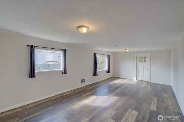View of living/dining from great room looking at front door.