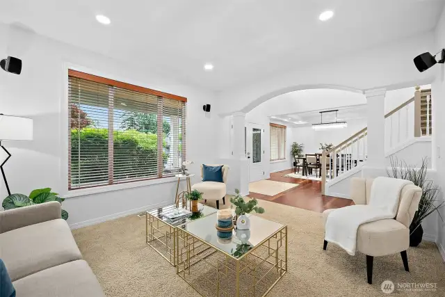 The formal living area boasts an arched entry with columns to accentuate the room transition.