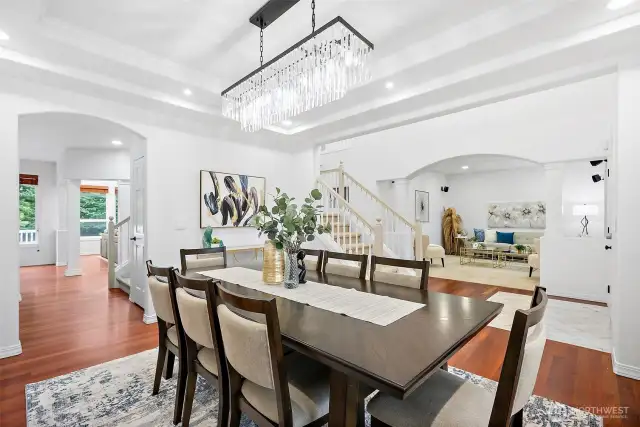 The formal dining area has custom lighting and is open to the formal living room and adjacent great room.