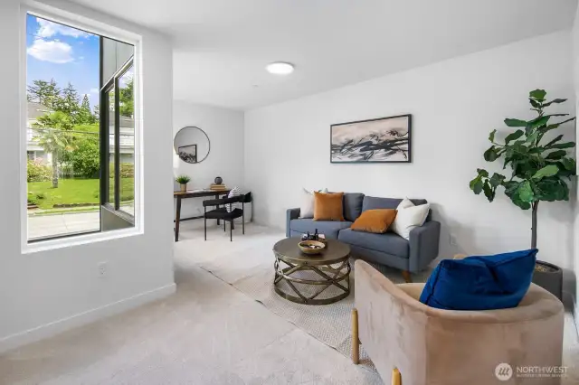Flexible lower-level lounge or media room—perfect for movie nights, play space, or a roomy WFH setup. Photos are of model home 8825, finishes and floorplan may vary.
