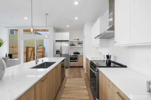 Sleek cooking zone with full-height backsplash, open shelving, and direct patio access for grill nights. Photos are of model home 8825, finishes and floorplan may vary.