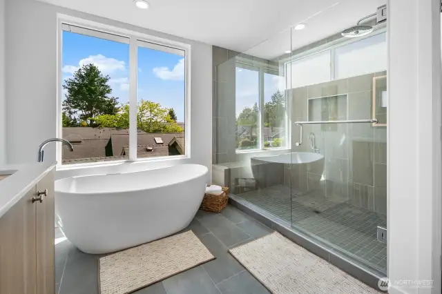 Spa-style bath upgrade: soaking tub beside picture windows plus glass shower enclosure. Photos are of model home 8825, finishes and floorplan may vary.