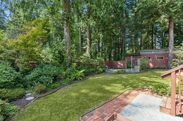 Big back yard and view of the detached garage and shop