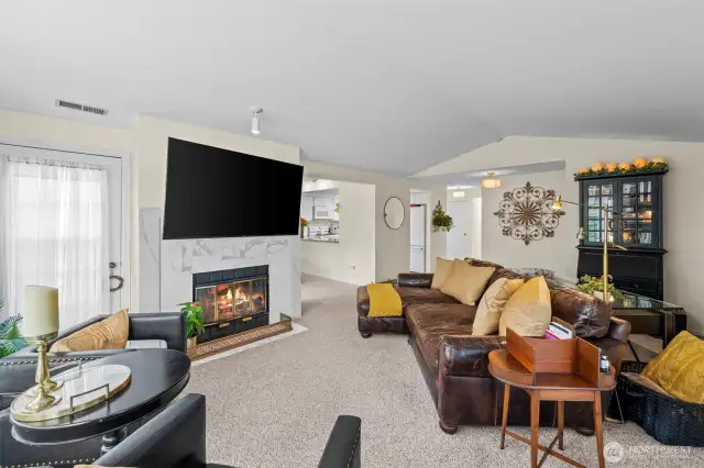Living room has vaulted ceilings and fireplace