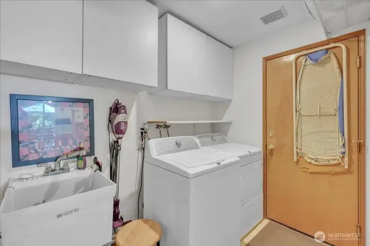 Laundry room with storage and door to the 3 car garage.