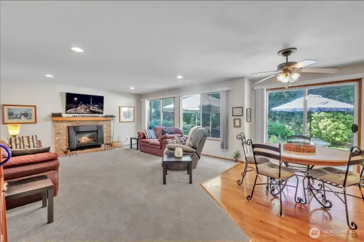 Cozy family room with gas fire place, large windows that fill the space with natural light, bright breakfast nook, and sliding glass door leading to back yard.