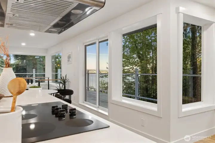 The spacious kitchen features a sunlit breakfast nook with sliding doors leading to the deck