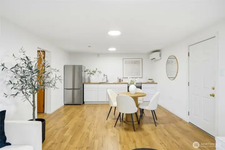 Open lower-level dining and living space with updated flooring and bright finishes.