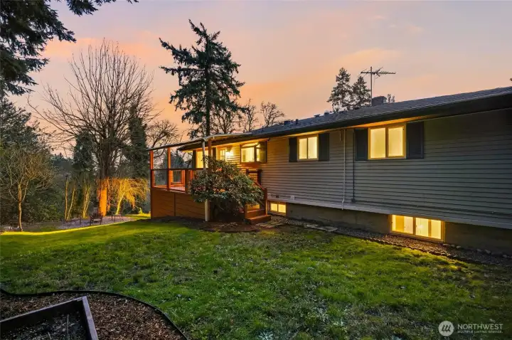 Side yard view of this two-level Kent home with mature landscaping and large lot.