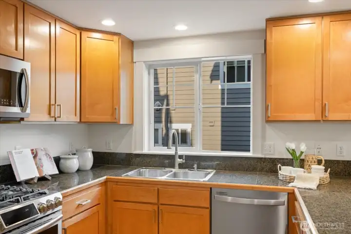 A bright window above the sink brings natural light into this well designed kitchen workspace.