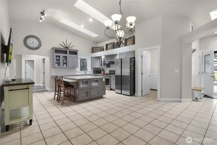 Large open kitchen design with expansive center island and bar is both functional and visually appealing.  The skylights bring in plenty of natural light making this space even more inviting.