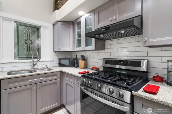 Kitchen also includes a gas range with high quality range hood and large stainless steel sink.  The relight window above sink adds a splash of character!