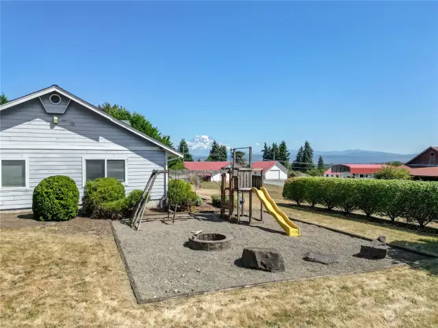 Play Set with firepit on gravel right next to the detached garage!