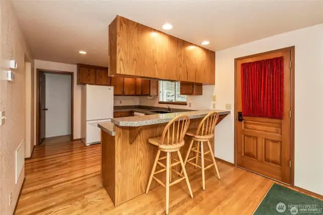 The back door exits to the south side of the house and kitchen goes into the pantry/utility room, the hallway is on the left.  Note the hardwood flooring.