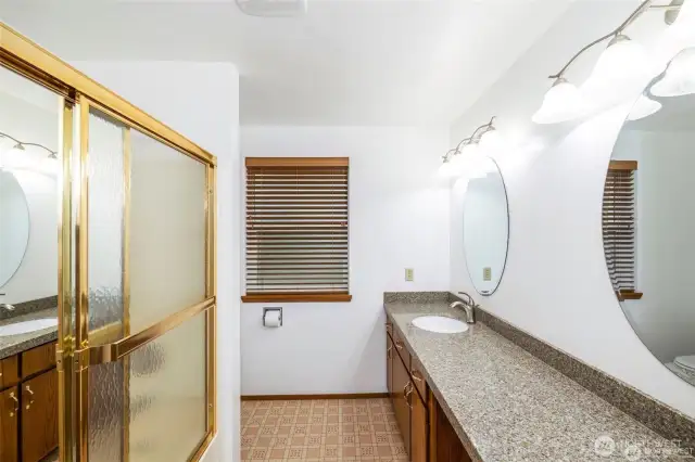 Upstairs bath has dual sinks, a tub shower combination and toilet.