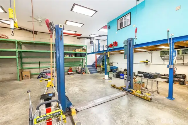 Want a car lift?  It stays and can come in handy.  Note the tall green commercial industrial grade metal shelving on the back wall.  The two red colored pull-down-stairs in the ceiling allows for easy storage in the attic area.