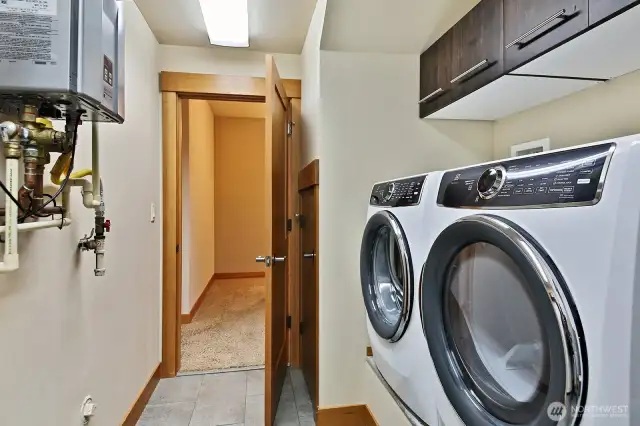 Lower Lever - Utility room. Built in cabinets & tankless water heater. There is a door that takes you outside to the side yard and generator.