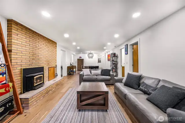 Wide layout flows from fireplace to dining and kitchen—offering open-concept design.