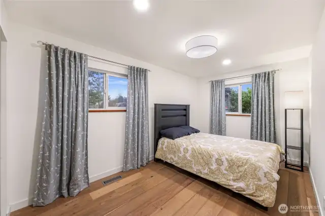 Dual windows, soft tones, and greenery views make this bedroom a restful retreat.