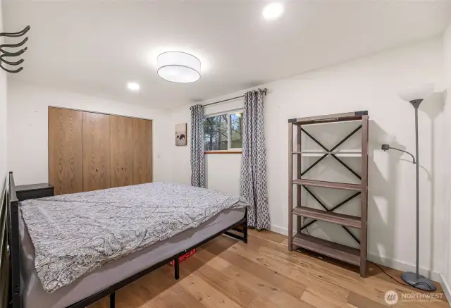 Guest bedroom with large closet, neutral finishes, and natural light.