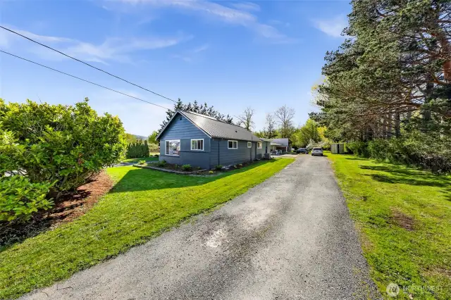 A long private driveway leads you home, bordered by mature trees and green space—offering privacy and RV parking.