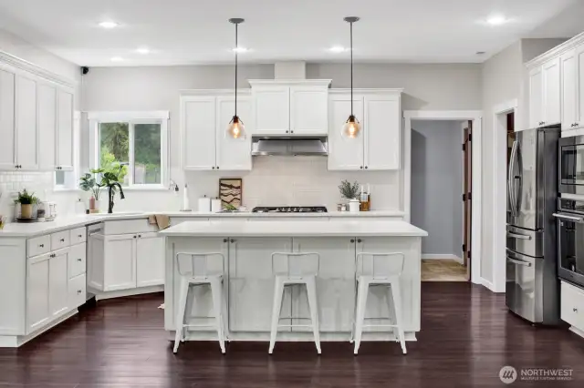 The kitchen is a chef's delight with abundant cabinets, stainless appliances, and a gas stove