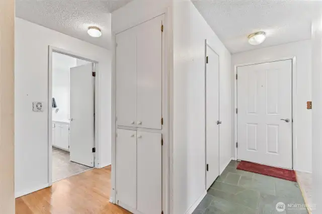 Hallway leads to bathroom and bedrooms with storage cabinets along the way.